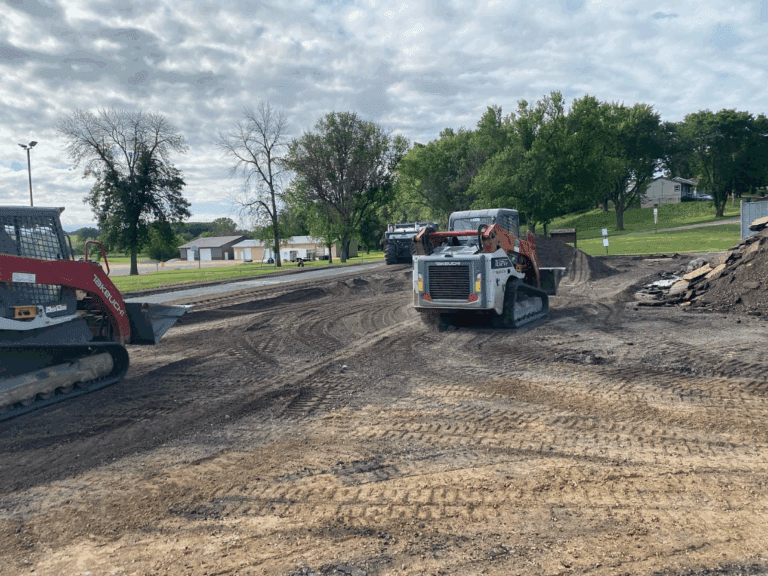 2 skidsteers prepping parking lot