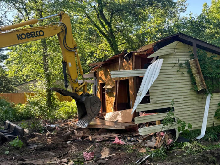 Light-demo-2 A small home or shed being demolished by an excavator