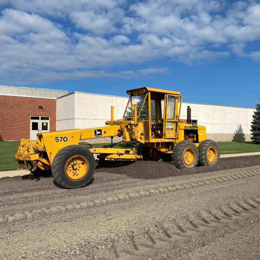 Scraper prepping parking lot