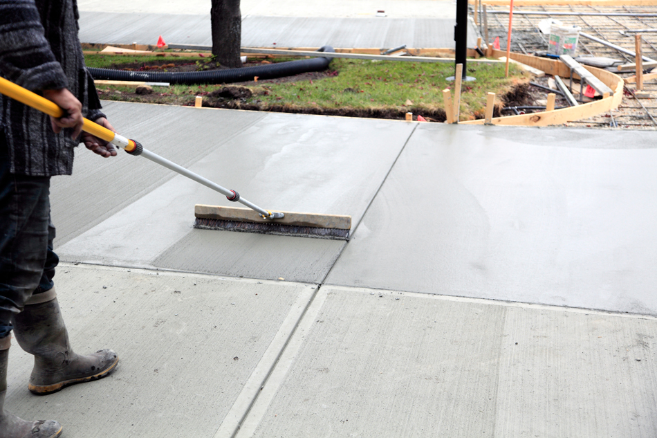 Man working on smoothing a driveway